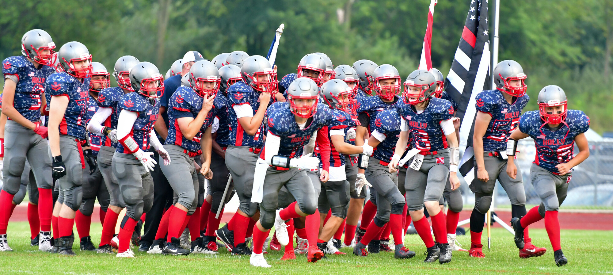 Football players after their initial huddle with their jerseys for the First Responders Game