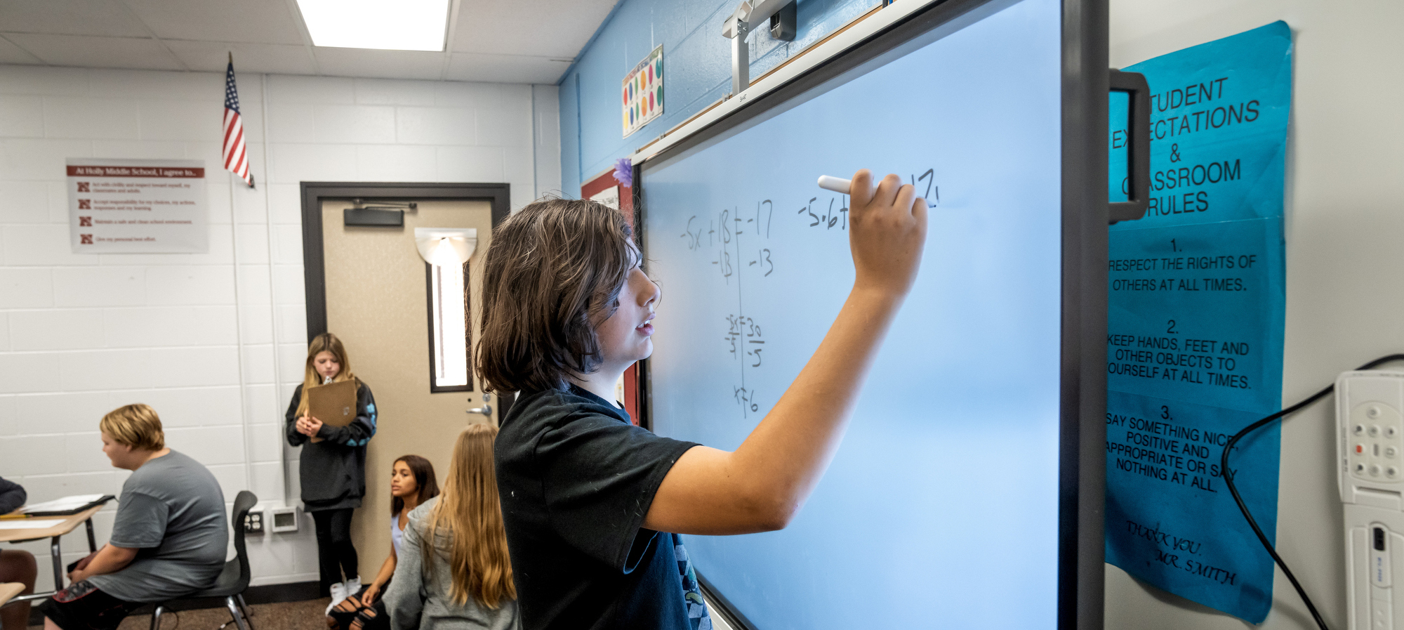 Student using smartboard to solve math problem