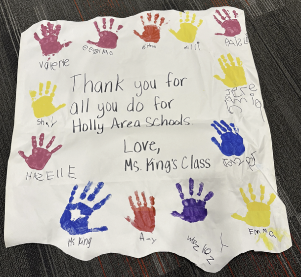 Banner with “Thank you for all you do for Holly Area Schools. Love, Ms. King’s Class” and handprints